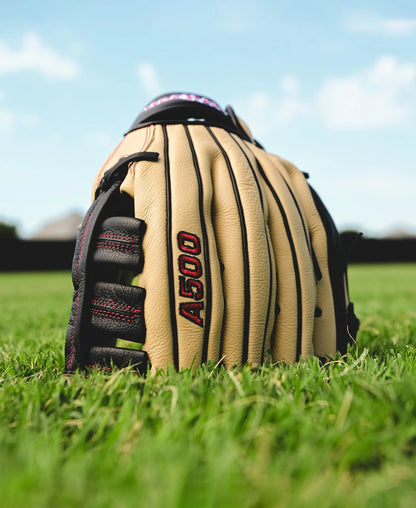 A Wilson A500 12.5" Baseball Glove (WBW102544125) by Wilson sits on the grass, ready for action.