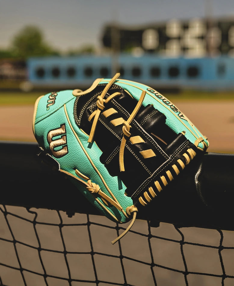 A Wilson A2000 1716SS 11.5" Baseball Glove, crafted with Pro Stock leather, rests on the fence, ready for the next play.