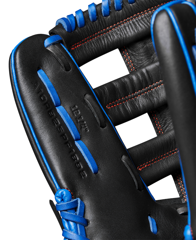 Close-up of the Wilson A1000 PF1892 12.25" baseball glove, featuring black full grain leather, blue laces, red stitching, open webbing, and "12.25" stamped on the leather. Model: WBW1025831225.