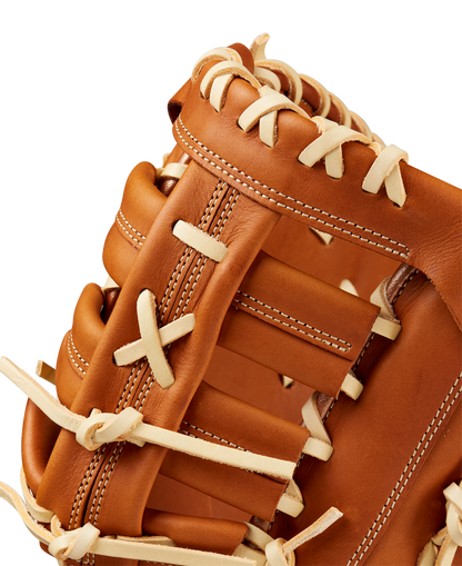 Close-up of the Wilson A1000 1620 12.5" First Base Mitt (WBW102587125) in brown, highlighting detailed white laces and stitching with smooth full grain leather, set against a plain background.
