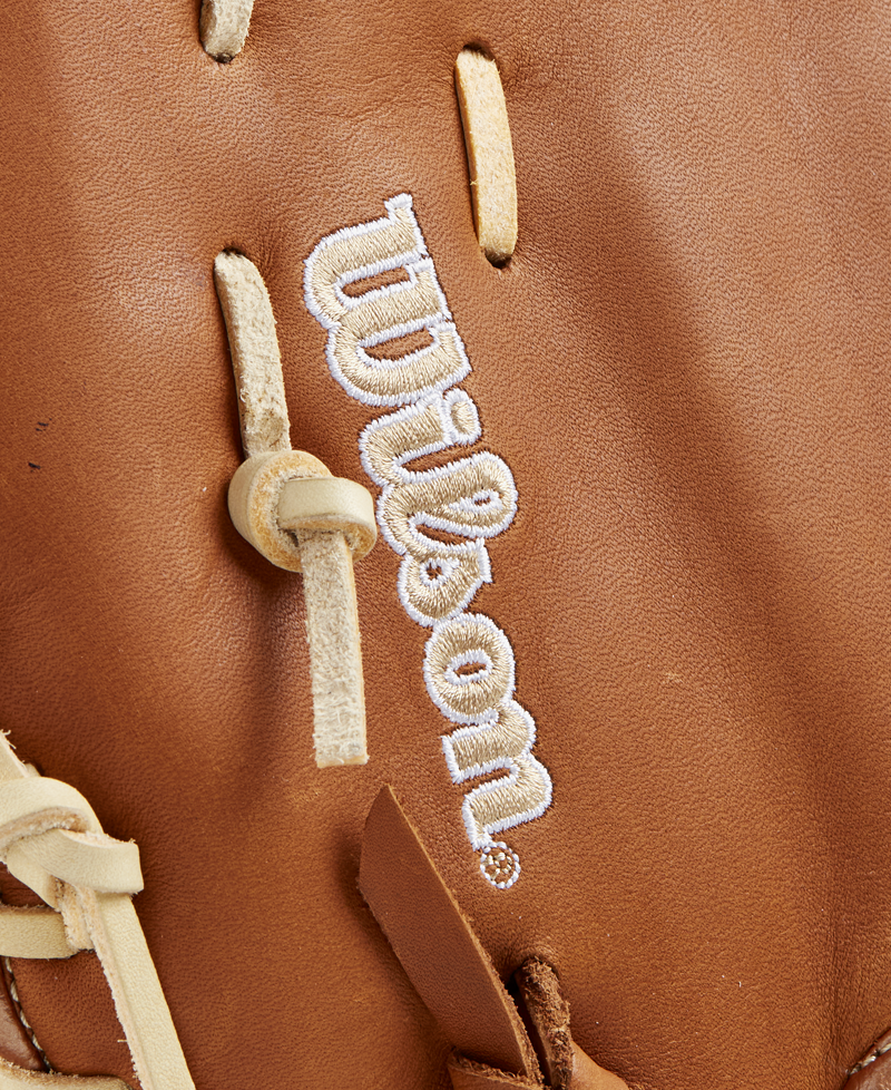 Close-up of a Wilson A1000 1620 12.5" first base mitt (WBW102587125), crafted from full grain leather with tan laces and white embroidered Wilson branding.