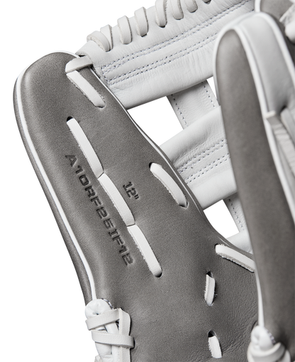 Close-up of a Wilson A1000 IF12 12" Fastpitch Glove by Wilson, featuring gray and white Full Grain leather, detailed stitching, laces, and embossed text WBW10259112 on the inside.