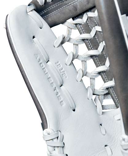 Close-up of the Wilson A1000 T125 12.5" Fastpitch Glove, crafted from full grain leather with detailed lacing and visible embossed text. The glove features white and gray colors, with stitching and leather details clearly shown.