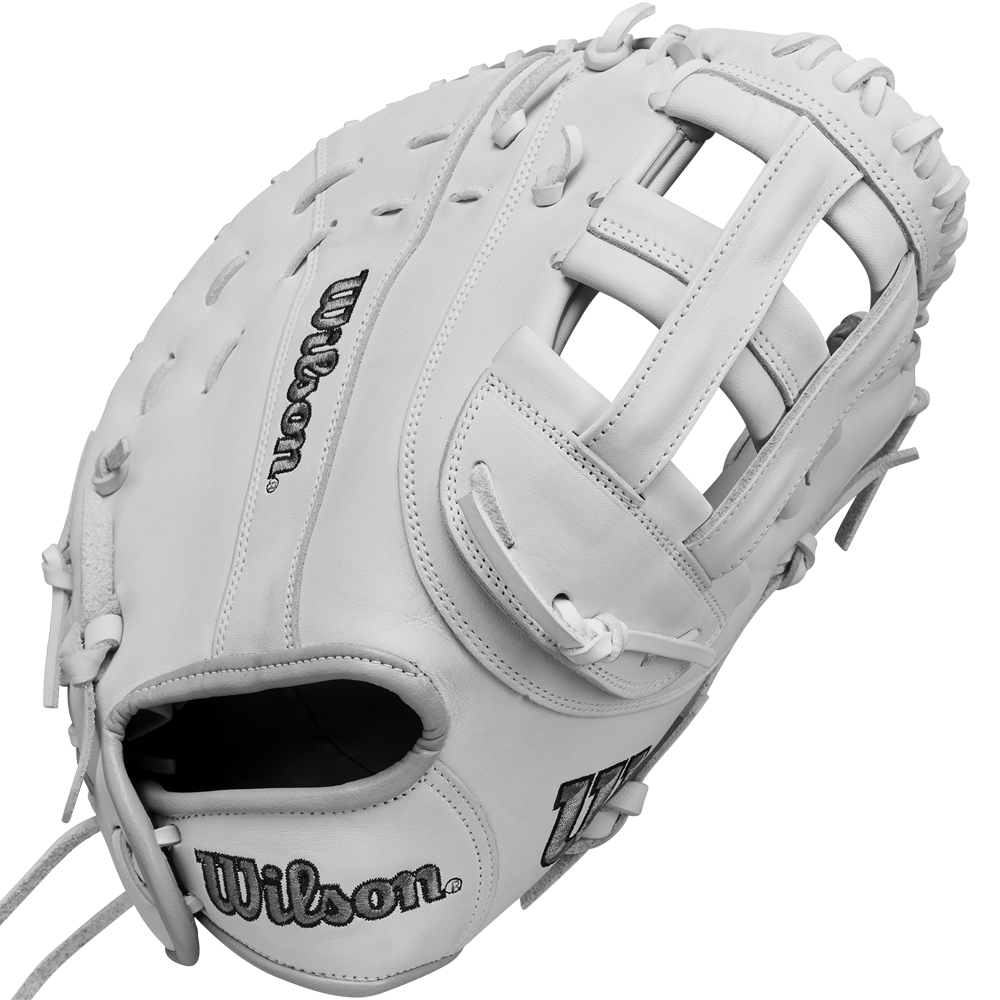 The Wilson A1000 1620 12.5" Fastpitch First Base Mitt (WBW102598125) is a white, full-grain leather mitt featuring visible stitching and laces, with the Wilson logo embroidered on the thumb and palm. Its webbing and pocket are clearly displayed.