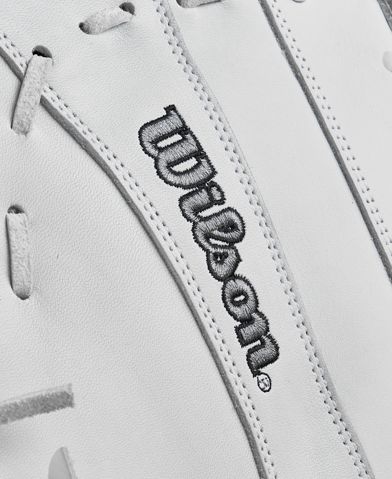 Close-up of the Wilson A1000 1620 12.5" Fastpitch First Base Mitt's white full-grain leather surface with gray laces and Wilson embroidered in black, highlighting its premium quality.