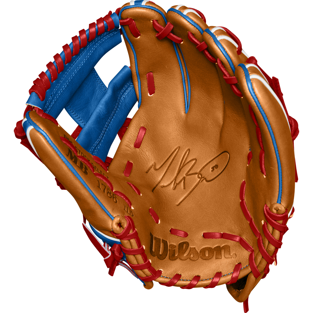 A tan Wilson A2K 1786 11.5" Mookie Betts GM baseball glove with blue/red lacing and the Wilson logo stamped on the palm, made from Pro Stock Select leather. Glove is open to display its inner side. Model: WBW102616115, Fall 2024.