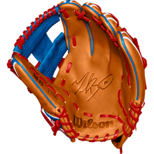 A tan Wilson A2K 1786 11.5" Mookie Betts GM baseball glove with blue/red lacing and the Wilson logo stamped on the palm, made from Pro Stock Select leather. Glove is open to display its inner side. Model: WBW102616115, Fall 2024.