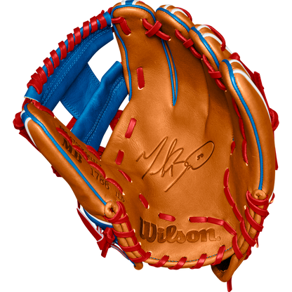 A tan Wilson A2K 1786 11.5" Mookie Betts GM baseball glove with blue/red lacing and the Wilson logo stamped on the palm, made from Pro Stock Select leather. Glove is open to display its inner side. Model: WBW102616115, Fall 2024.
