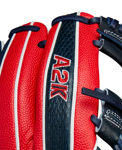 Close-up of the Wilson A2K 1724SS 11.75" Baseball Glove (FALL 2024) featuring red and navy blue Pro Stock Select leather, white stitching, black laces, textured surface, and "A2K" embroidered on the back.