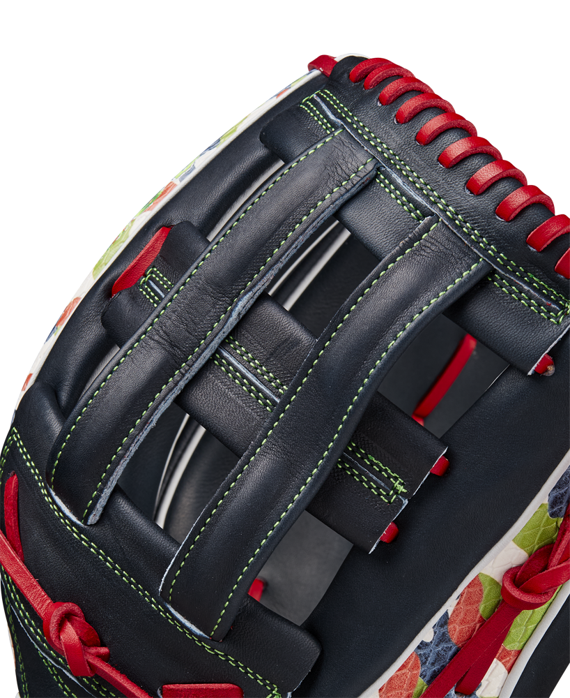 Close-up of the Wilson A2K MH23 12.75" Michael Harris GM Baseball Glove (WBW1026201275), crafted from Pro Stock Select leather in navy blue with red laces, green stitching, a floral pattern on the edge, and a woven web.