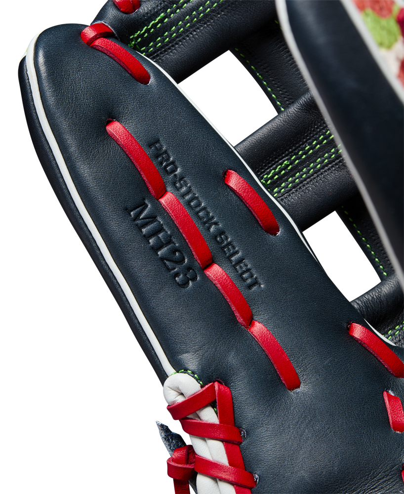 Close-up of a dark blue Wilson A2K MH23 12.75" Michael Harris GM baseball glove (WBW1026201275) with red laces, white stitching, and green accents. Made from Pro Stock Select leather and embossed with PRO STOCK SELECT and MTT23.