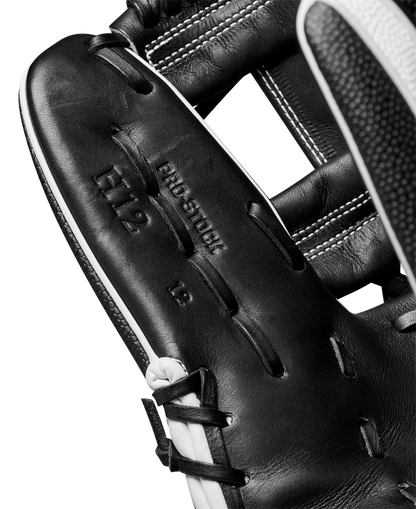 Close-up of a Wilson A2000 H12SS 12" Fastpitch Glove (WBW10262412) in black leather, featuring visible stitching, PRO STOCK H12 12 stamping on the palm, and premium SuperSkin material. Part of a baseball is seen at the edge.