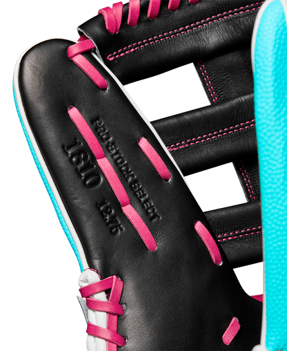 Close-up of a black Wilson A2K 1810SS 12.75" baseball glove with pink laces, light blue trim, and "PRO STOCK SELECT 1810 12.5" embossed on the leather. Model: WBW1026881275, Winter 2024 collection.