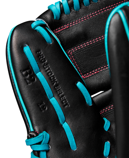 Close-up of the Wilson A2K B2 12" Baseball Glove, crafted from Pro Stock Select leather with bright blue laces, red stitching, a Closed 2-Piece Web, and inner palm markings including "PRO STOCK SELECT." Model: WBW10269212.