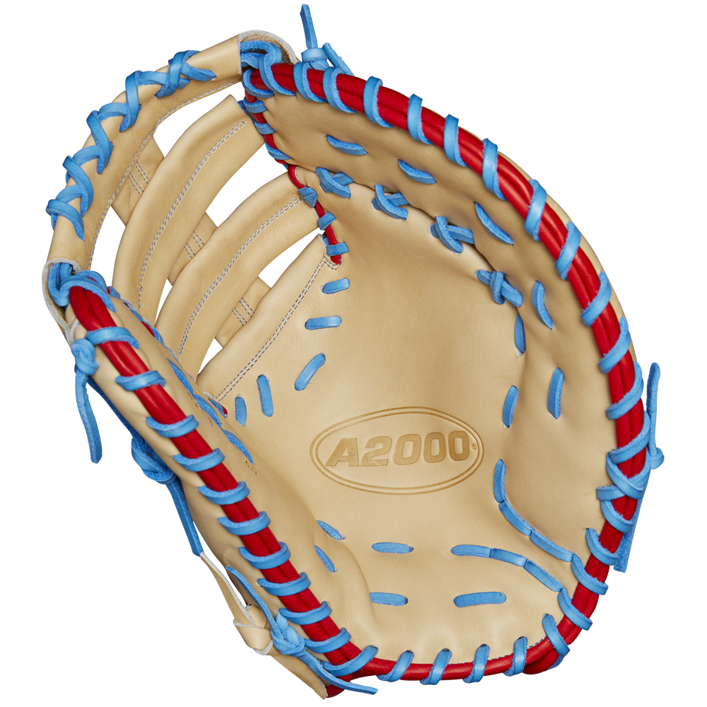 The Wilson A2000 1677 12.5" First Base Mitt (Spring 2025, WBW102753125) features tan Pro Stock leather, blue and red laces, detailed stitching, an open web, and the A2000 logo in the palm.