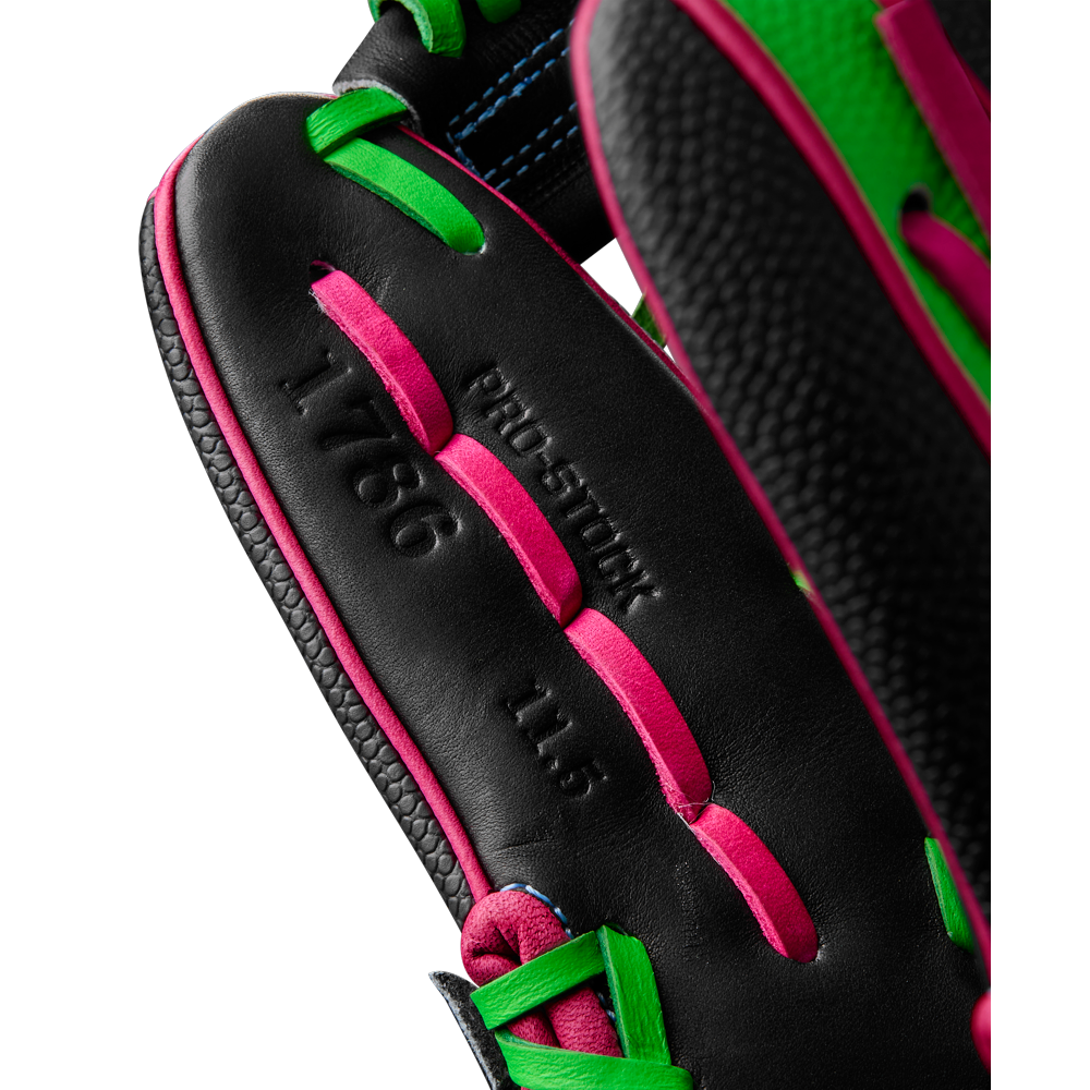 Close-up of the Wilson A2000 1786SS 11.5" Baseball Glove (WBW103218115), featuring black leather with pink and green laces. “PRO STOCK,” “1786,” and “11.5” are embossed, while SuperSkin provides durability and a lightweight feel.