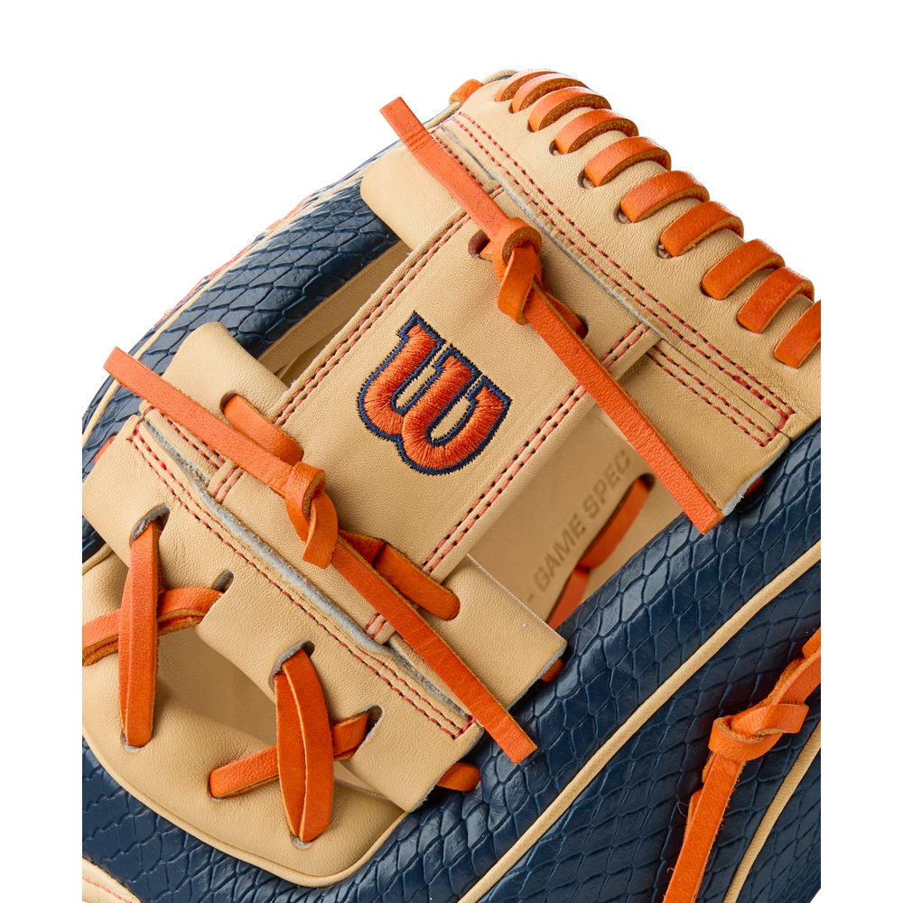 Close-up of the Wilson A2000 JA27 11.5" Jose Altuve GM Baseball Glove, Summer 2025: WBW103295115, featuring blue textured Pro Stock leather, tan accents, orange laces, and an embroidered W logo in blue and orange on a tan strap.