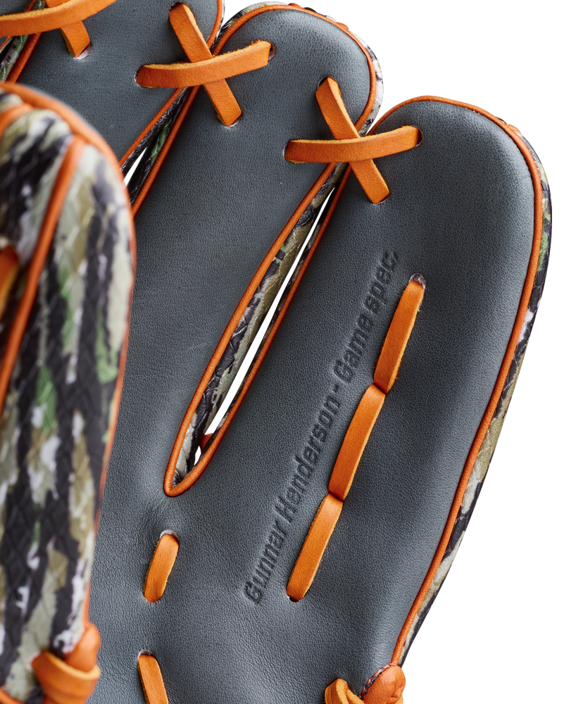 Close-up of the Wilson A2000 GH2 11.75" Gunnar Henderson GM Baseball Glove’s palm, showing orange laces, a camouflage edge, and the “Gunnar Henderson - Game Spec.” embossing. Model: WBW1034511175.