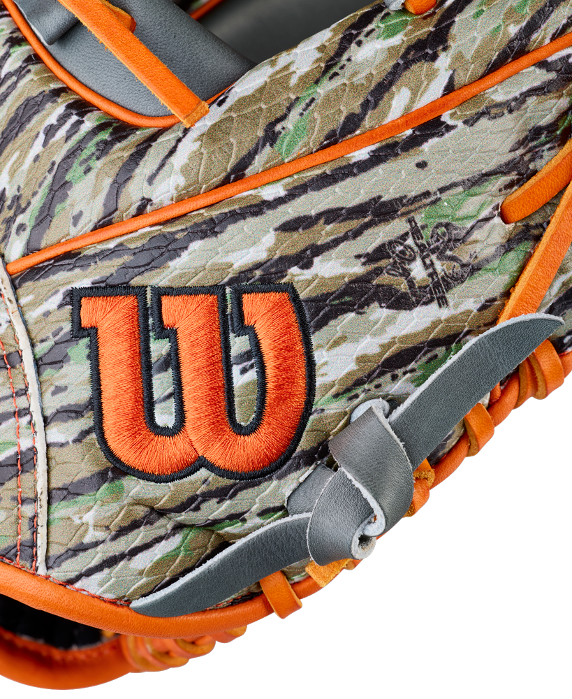 A close-up of the Wilson A2000 GH2 11.75" Gunnar Henderson GM Baseball Glove, showcasing its camouflage design with orange trim and a prominent orange and black Wilson "W" logo on the side.