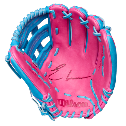 A close-up of the Wilson A2000 EDLC44 12" Elly De La Cruz Gameday Baseball Glove shows its pink leather with blue trim and laces, a black signature on the palm, and the embossed Wilson logo—FALL 2025 model WBW10345212.