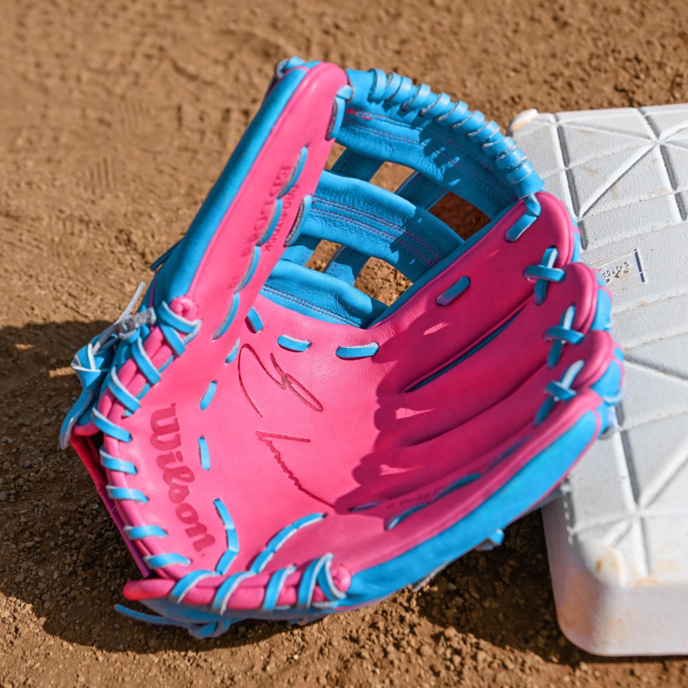 A Wilson A2000 EDLC44 12" Elly De La Cruz Gameday Baseball Glove (FALL 2025) rests open on the infield dirt beside a white base.