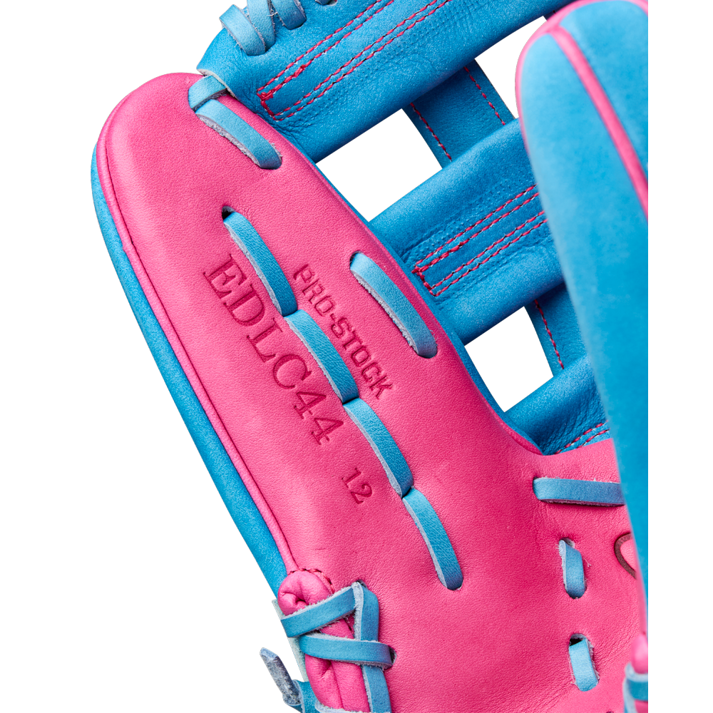 Close-up of the Wilson A2000 EDLC44 12" Elly De La Cruz Gameday Baseball Glove in bright pink and blue, featuring embossed text "PRO STOCK," "EDLC44," and "12" on the palm—ideal as a 12” infield glove. Model: WBW10345212, FALL 2025.
