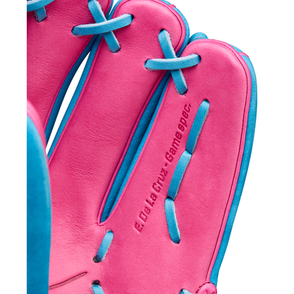 Close-up of the Wilson A2000 EDLC44 12" Elly De La Cruz Gameday Baseball Glove with blue laces and "E. De La Cruz - Game Spec." stamped into the pink leather. Model: WBW10345212, coming FALL 2025.