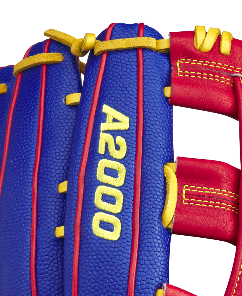 Close-up of a blue Wilson A2000 1799SS 12.75" Pete Crow-Armstrong GM Baseball Glove (GOTM January 2025) with red and yellow accents, yellow stitching, and "A2000 1799SS" embroidered in yellow on the glove's surface.