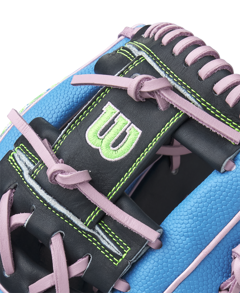 Close-up of the Wilson A2000 1786SS 11.5" Baseball Glove (GOTM March 2025) in blue with pink laces, black Pro Stock leather, green stitching, and a green embroidered W logo.