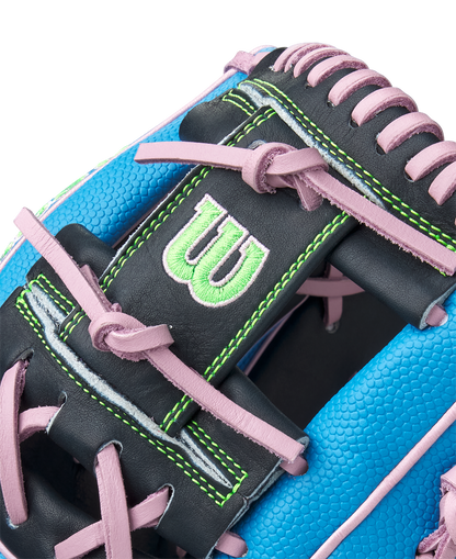 Close-up of the Wilson A2000 1786SS 11.5" Baseball Glove (GOTM March 2025) in blue with pink laces, black Pro Stock leather, green stitching, and a green embroidered W logo.