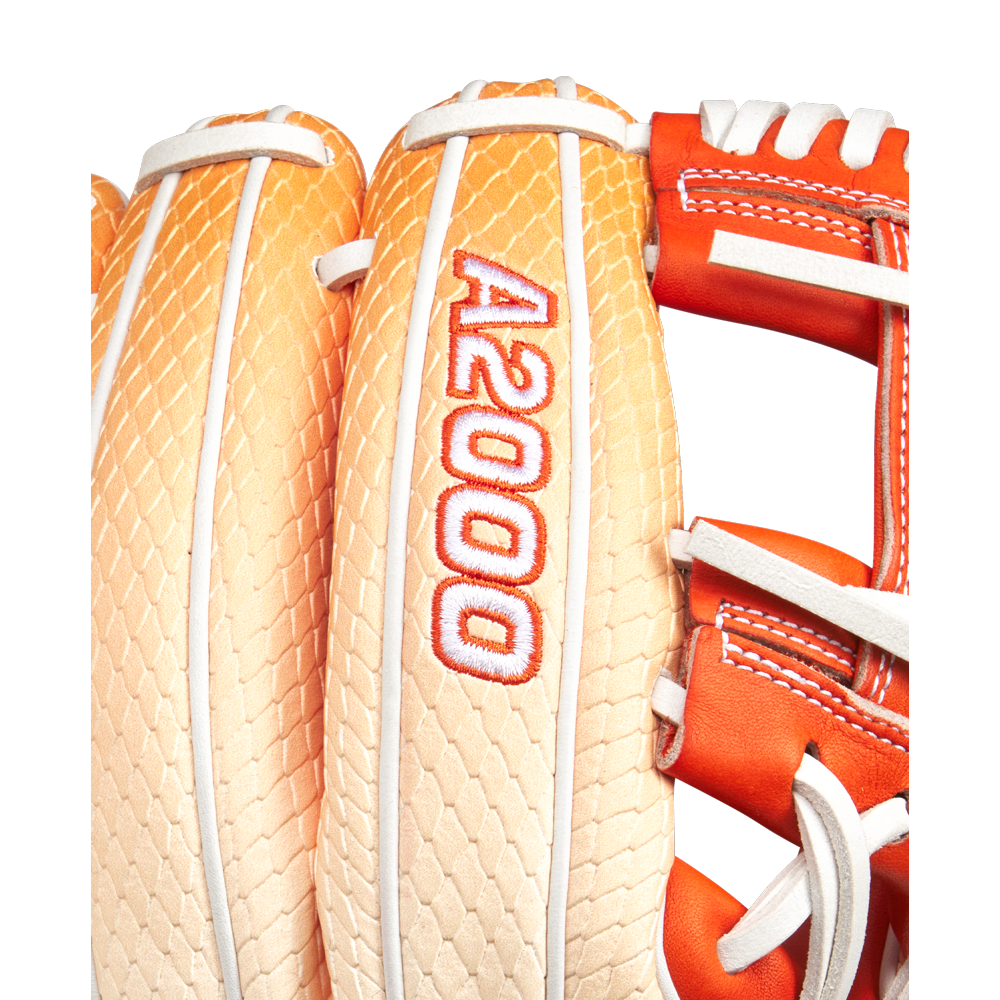 Close-up of a tan and orange Wilson A2000 1975SS 11.75" Baseball Glove (GOTM June 2025) featuring Pro Stock leather with white stitching, red A2000 embroidery, and a textured, scale-like pattern on the back.
