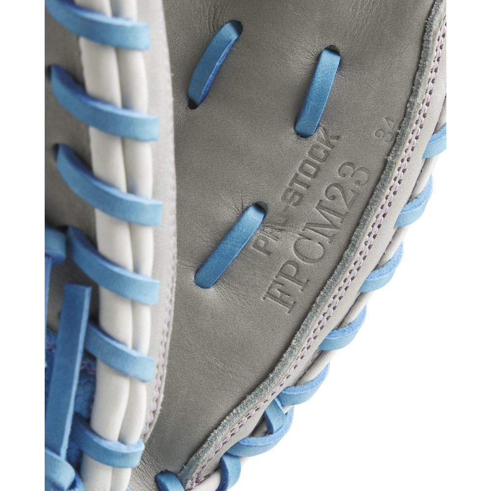 Close-up of a Wilson A2000 FPCM23 34" Fastpitch Catcher's Mitt (model WBW10349134) in gray with blue and white laces, showing embossed PRO STOCK and FPCM23 34 on the leather. Brand: Wilson. FALL 2025 release.