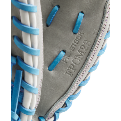 Close-up of a Wilson A2000 FPCM23 34" Fastpitch Catcher's Mitt (model WBW10349134) in gray with blue and white laces, showing embossed PRO STOCK and FPCM23 34 on the leather. Brand: Wilson. FALL 2025 release.