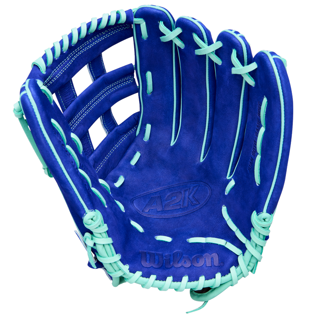 A Wilson A2K JS22 12.75" Juan Soto GM Baseball Glove by Wilson, featuring blue Pro Stock Select leather with mint green laces and accents, is displayed open with the palm facing up against a white background.