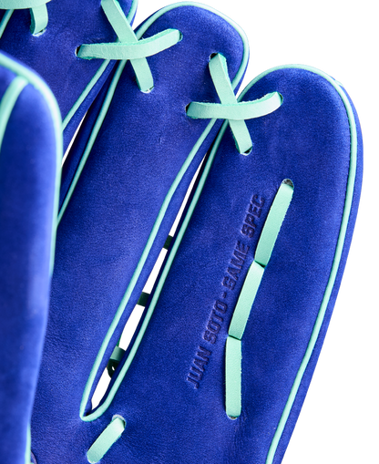 Close-up of the Wilson A2K JS22 12.75" Juan Soto GM Baseball Glove by Wilson, featuring blue Pro Stock Select leather with light green laces and trim, and "JUAN SOTO - GAME SPEC" embossed on the surface.