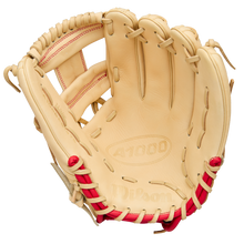 A tan Wilson A1000 1975 11.75" youth infield glove with red stitching and laces is shown open, displaying the pocket and finger slots. The palm is embossed with Wilson and A1000. Model: WBW1039591175.