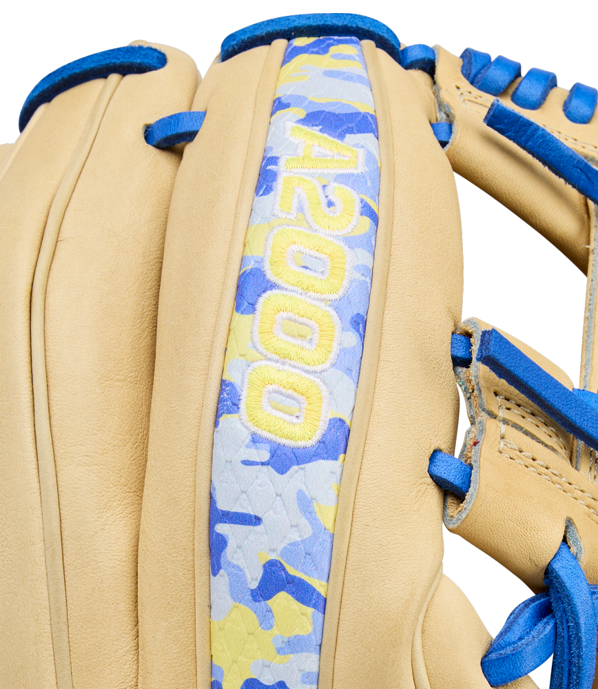 Close-up of the Wilson A2000 BWJ7 11.75" Bobby Witt Jr. GM Baseball Glove (WBW1040681175), featuring tan Pro Stock leather, blue laces, a blue/yellow/gray camo strip, and yellow “A2000” embroidery for infielders.