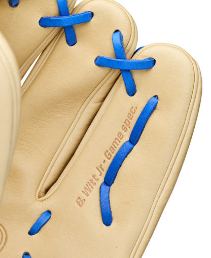 A close-up of a tan Wilson A2000 BWJ7 11.75" Bobby Witt Jr. GM baseball glove with blue laces, featuring "B. Witt Jr. Game Spec." stamped near the base of the fingers. Model: WBW1040681175.