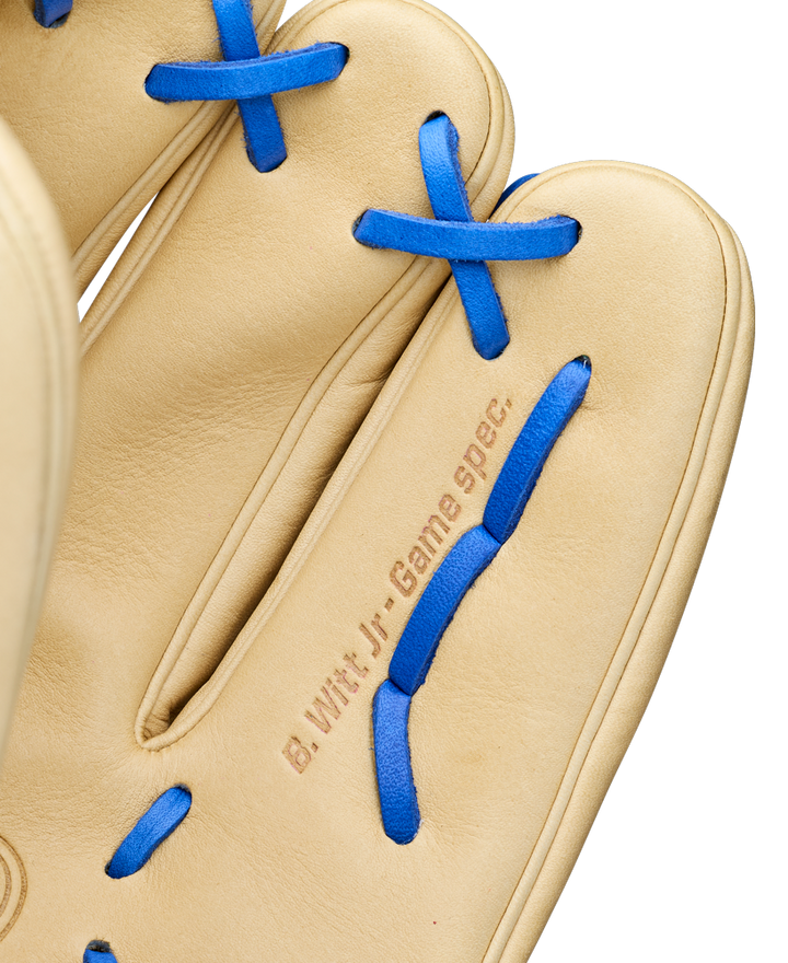 A close-up of a tan Wilson A2000 BWJ7 11.75" Bobby Witt Jr. GM baseball glove with blue laces, featuring "B. Witt Jr. Game Spec." stamped near the base of the fingers. Model: WBW1040681175.
