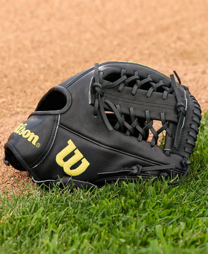 A Wilson A2000 1789 11.5" baseball glove (model WBW104106115) with yellow lettering lies on green grass near the infield, crafted from premium Pro Stock leather.