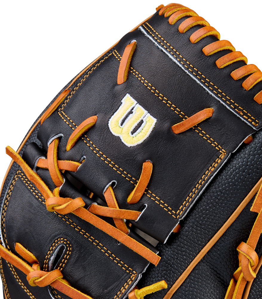 Close-up of a black Wilson A2000 B125SS 12.5" Baseball Glove (WBW104119125) with orange laces, yellow stitching, and a bold white and yellow W logo embroidered on a rectangular leather patch.