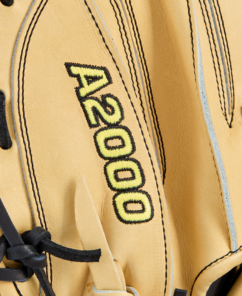 Close-up of a tan Wilson A2000 1734 34" Baseball Catcher's Mitt (WBW10412934) with black laces and A2000 stitched in yellow and black on the surface.