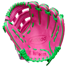 A vibrant pink Wilson A2000 JR11 12" José Ramírez GM Baseball Glove (WBW10413512) with green laces and stitching is displayed open, palm up, against a white background.