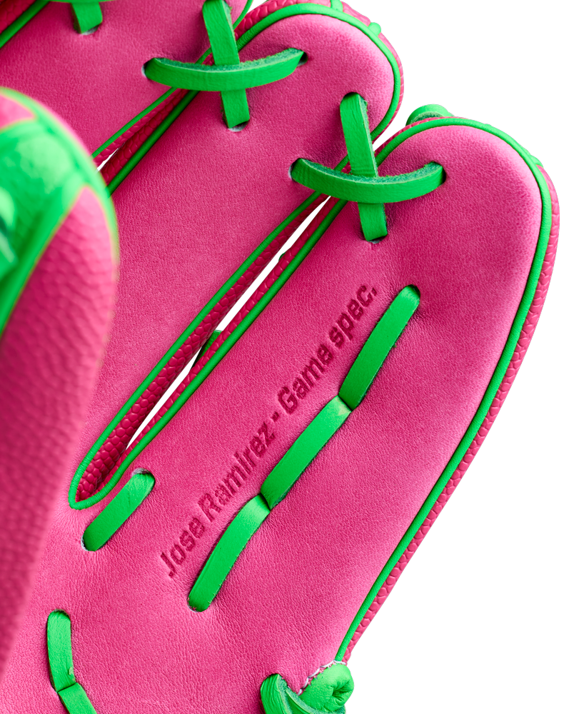 Close-up of the Wilson A2000 JR11 12" José Ramírez GM baseball glove (WBW10413512) in pink with green laces and trim, featuring “José Ramírez - Game spec.” embossed inside.