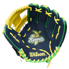 The Wilson A450 Savannah Bananas 11" Youth Baseball Glove (WBW10419211) features navy blue color, yellow and green laces, a cartoon banana with a bat, "Bananas" embroidery on the palm, and a classic H-Web design.