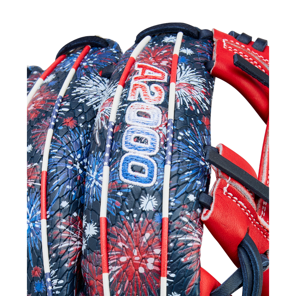 Close-up of the Wilson A2000 1975SS 11.75" Baseball Glove (GOTM July 2025), featuring a red, white, and blue fireworks pattern, white laces, and "A2000" stitched in blue and white on the back.