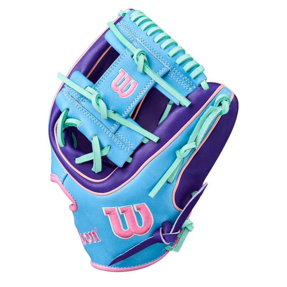 The Wilson A2K 1720 11.5" Baseball Glove (GOTM October 2025, WBW104220115) features blue, purple, and pink Pro Stock Select leather with teal laces and a pink Wilson logo on the wrist and thumb.