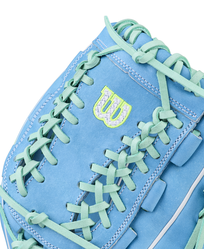 Close-up of the Wilson A2000 FPHG 12" Fastpitch Glove (WBW10423512): light blue with turquoise laces, white stitching, and a neon green/white W logo near the thumb. Made from Pro Stock leather for premium performance.