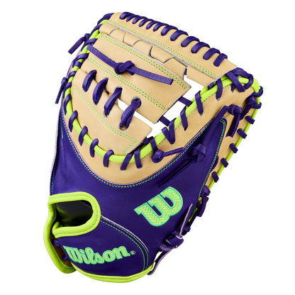 The Wilson A2000 FPCM23 34" Fastpitch Catcher’s Mitt features premium Pro Stock leather in tan with purple accents, bright green laces, and open web. Wilson’s logo stands out in bright green and teal, with colorful stitching for a bold look.