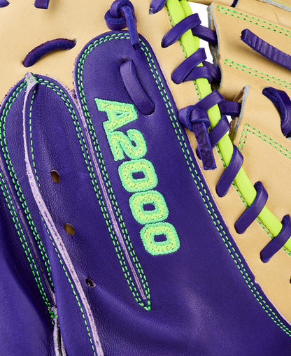 Close-up of the Wilson A2000 FPCM23 34" Fastpitch Catcher's Mitt (WBW10423934) featuring purple and tan Pro Stock leather, neon green stitching, purple laces, and green embroidered A2000 text on the purple section.